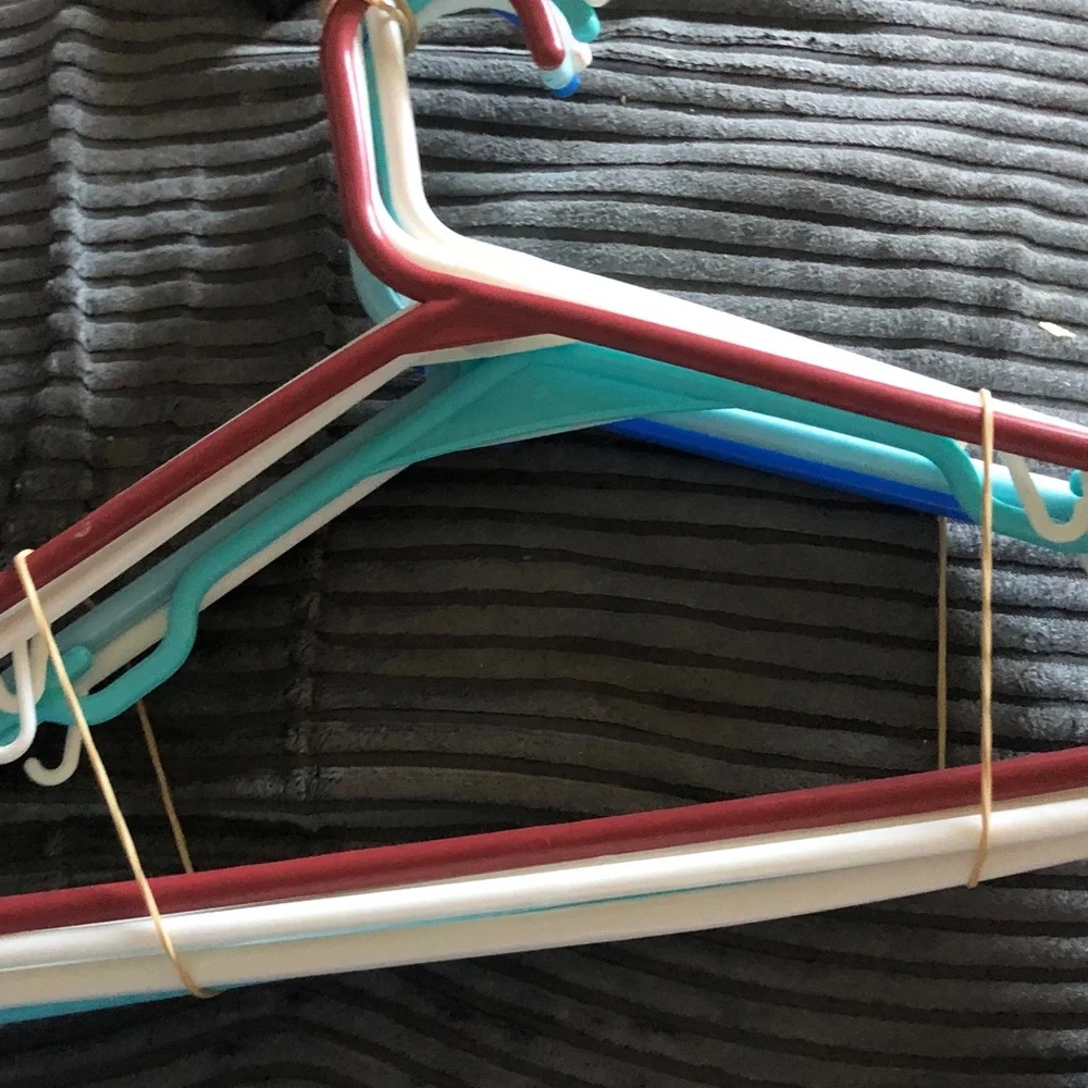 Assorted Plastic Clothing Hangers in Blue, White, Teal, and Burgundy